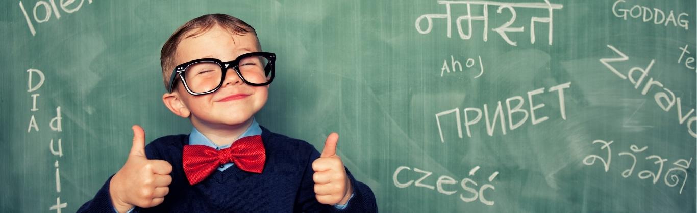 Multilingual child standing in front of blackboard