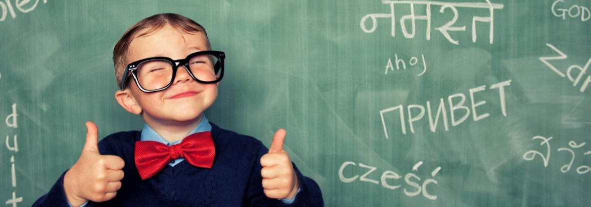 Multilingual child standing in front of blackboard